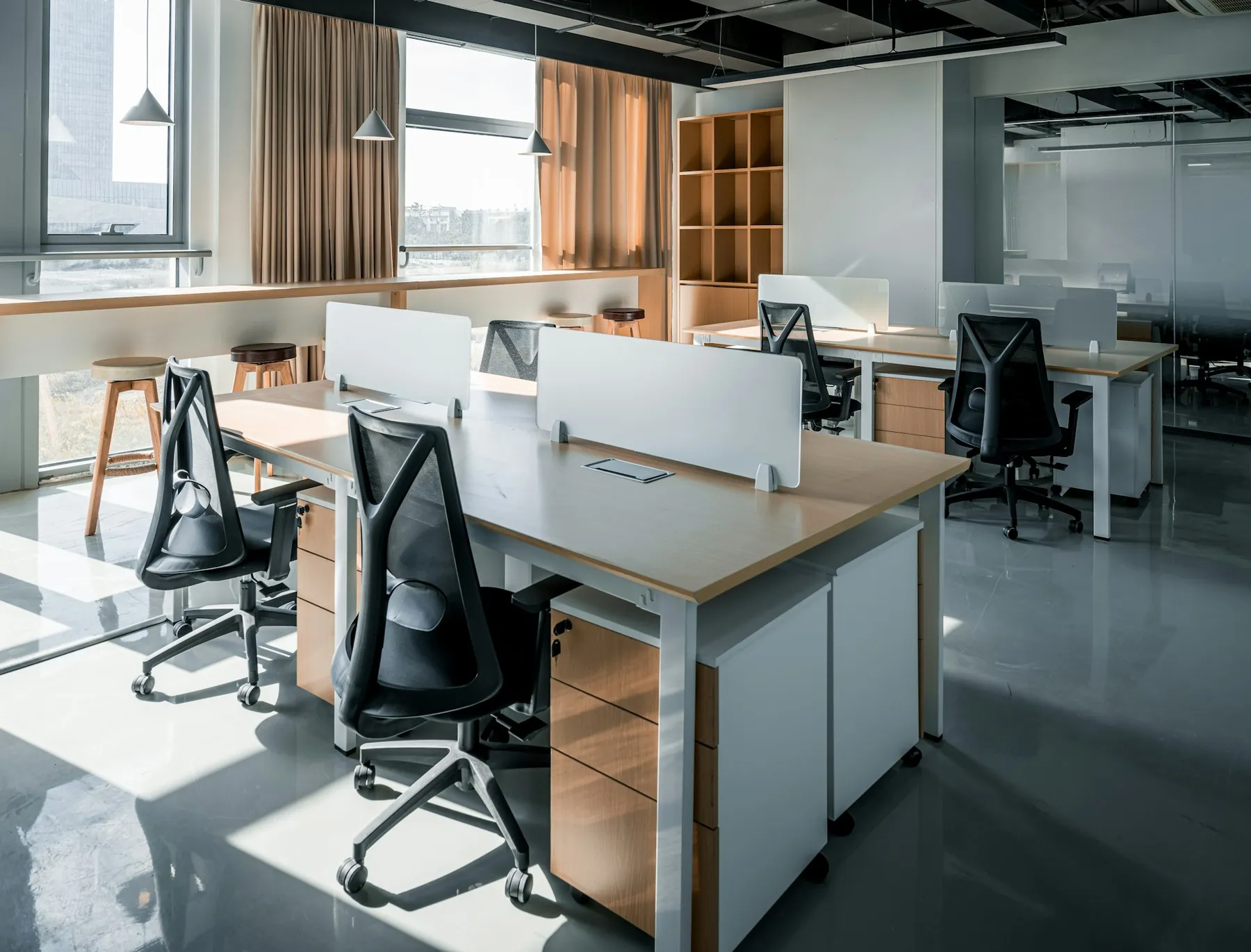 Modern empty office with desks, chairs and large windows